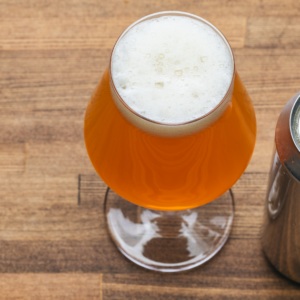 pint glass of craft beer next to open aluminum beverage can