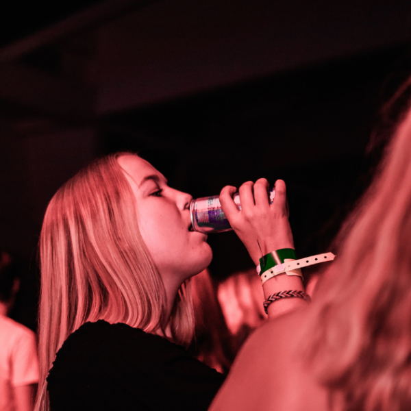 Woman drinking from a beverage can while outdoors