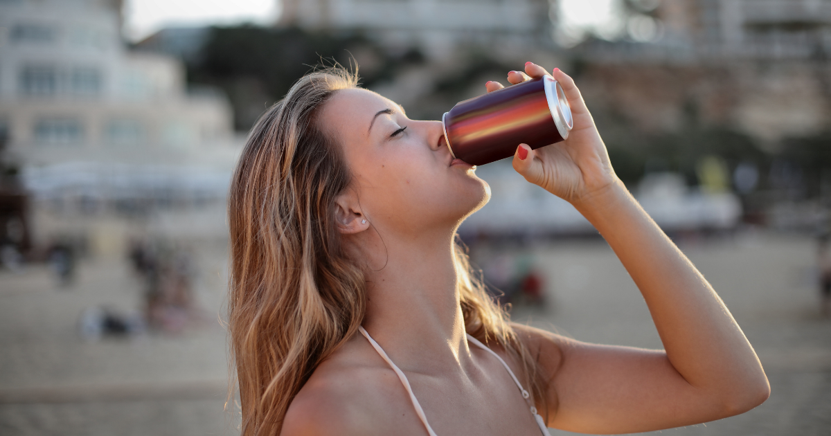 Woman drinking from an aluminum beverage can