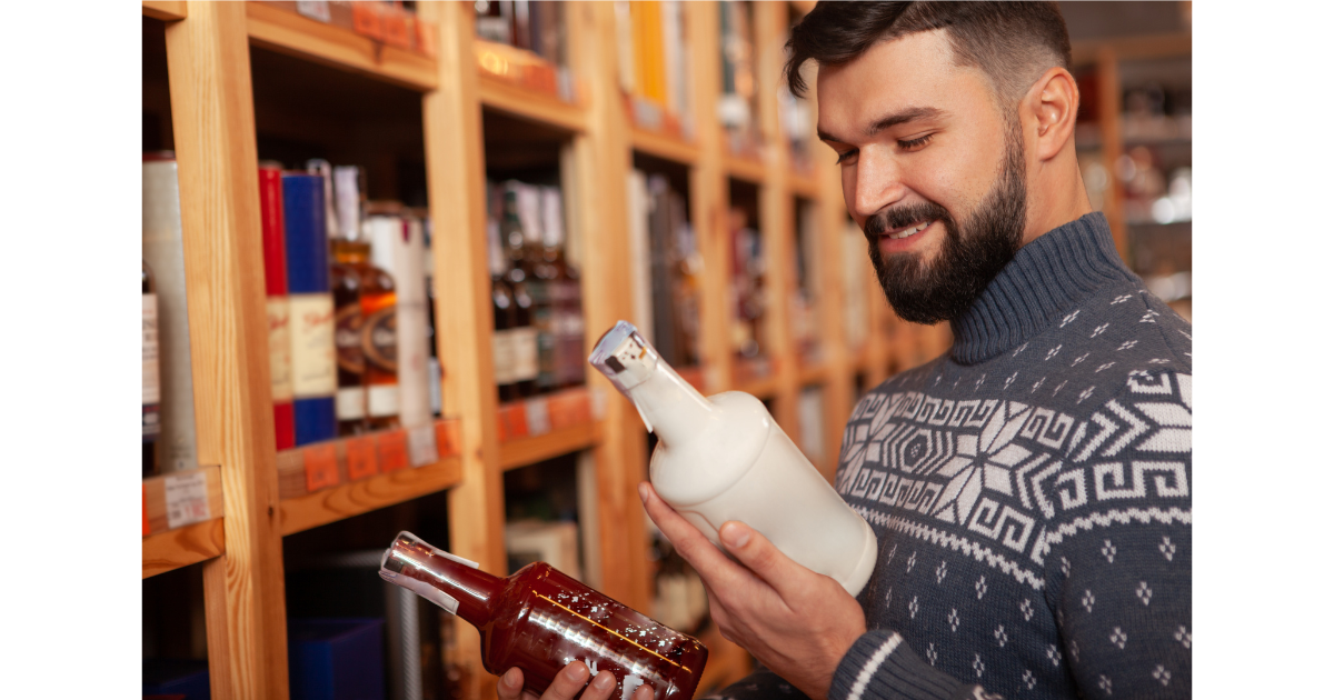 Man comparing two liquor bottles