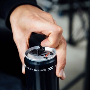 Person opening a beverage can with an XO resealable can end