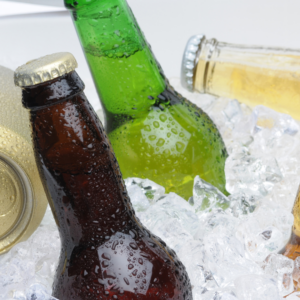 A cooler of ice filled with beer bottles and canned beer