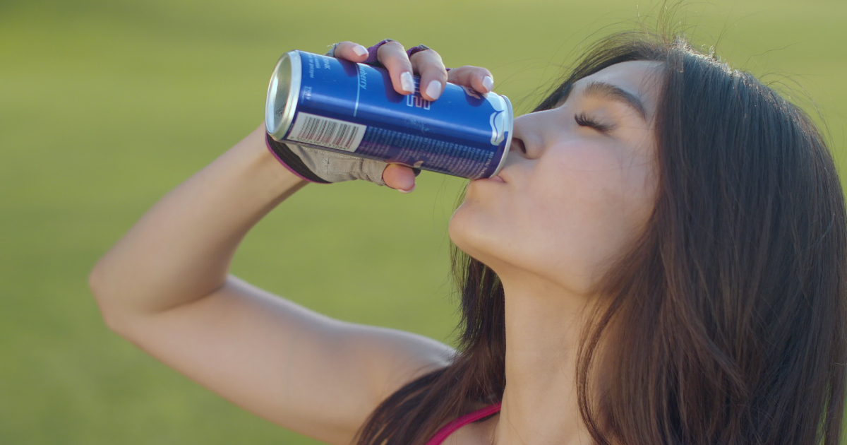 Woman drinking from beverage can