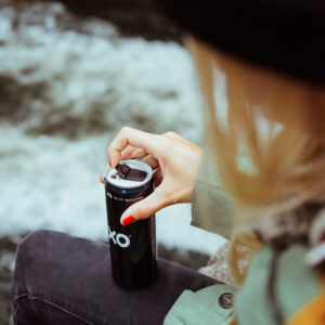 Woman opening a beverage can that has an XO resealable can end